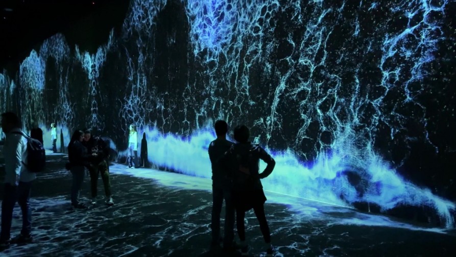 Digital waves lap at the feet in the Starry Beach room.