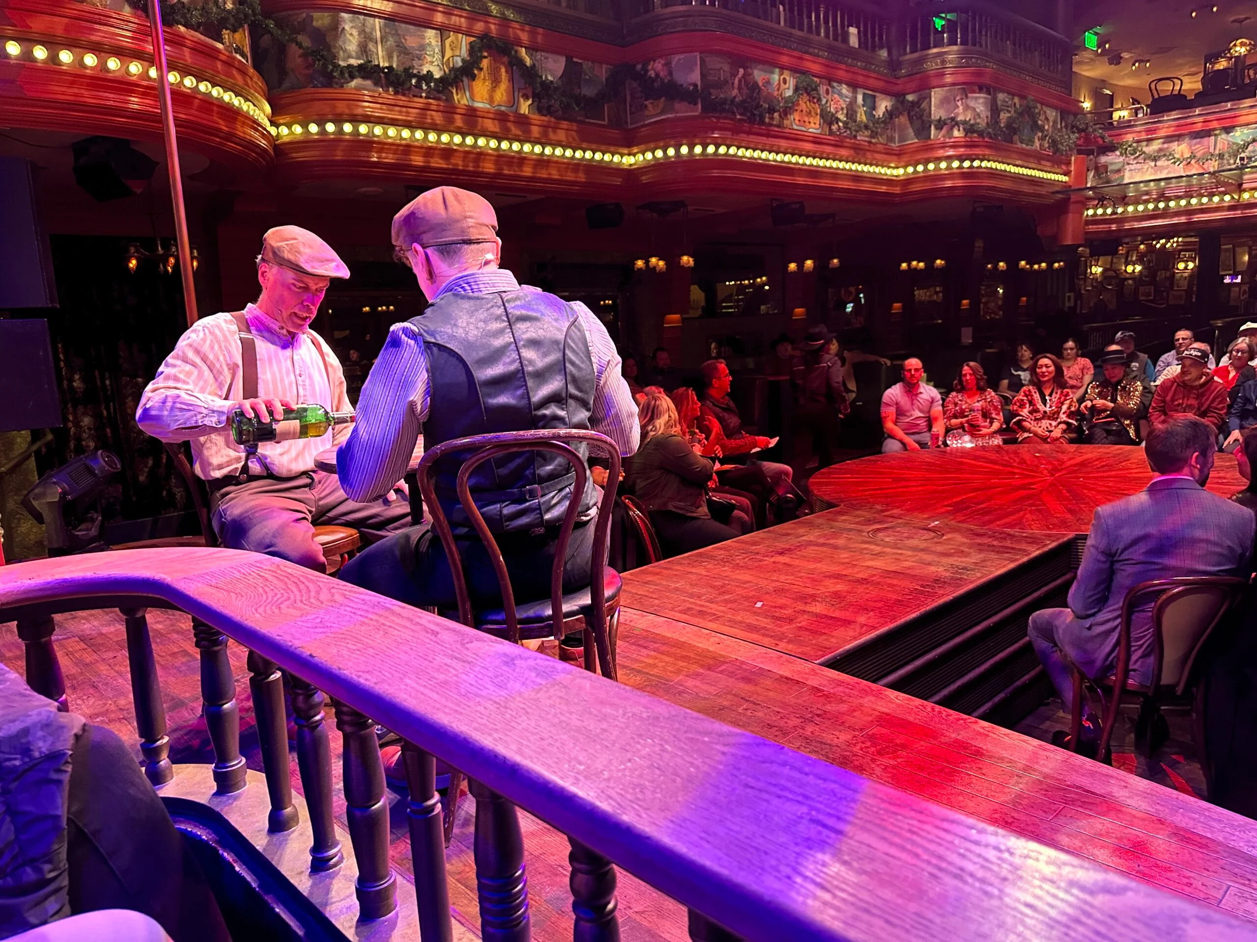 Two men pouring shots at Atomic Saloon on stage.