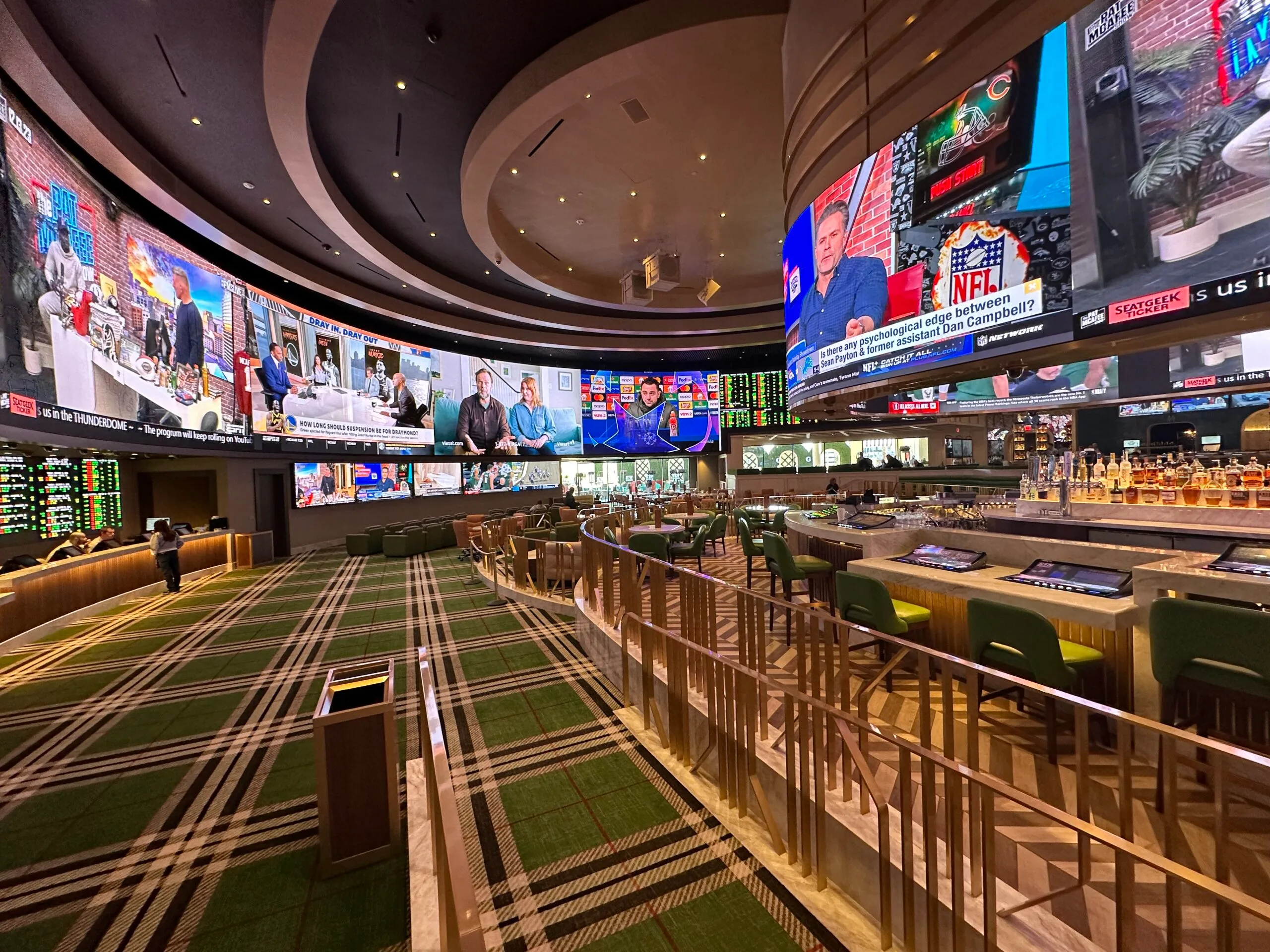 Another angle of the bar top wraparound screen and the main sportsbook screen in the background.