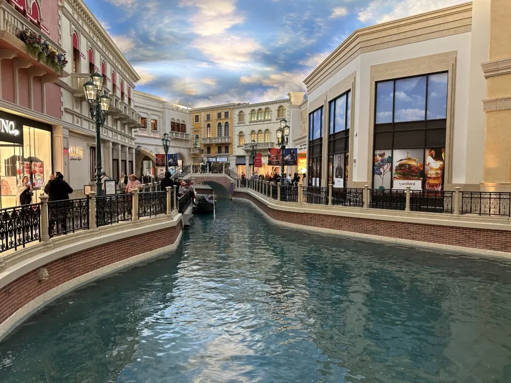 A water canal surrounded by venetian themed shops. 