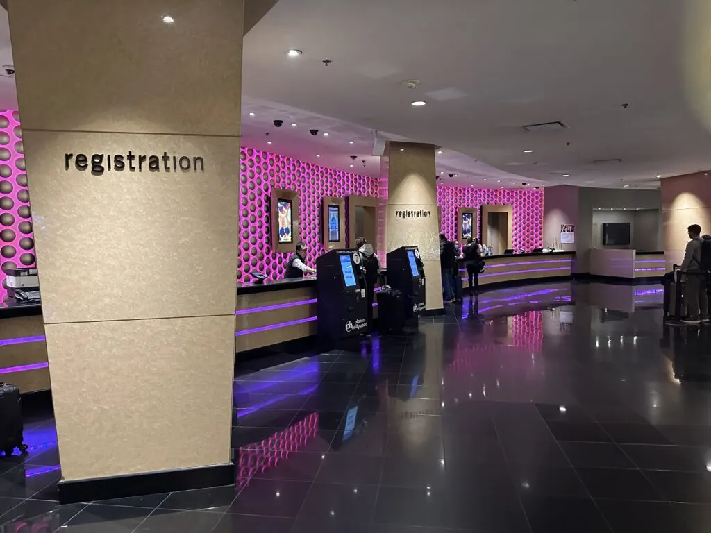 The hotel registration desk at Planet Hollywood, which has a purple illumnated back wall that gives off a trendy vibe.