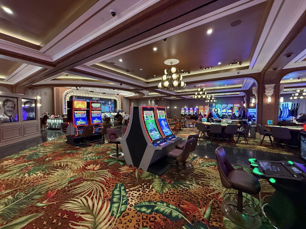 The new area of the casino, with slot machines scattered about and wooden ceilings. 