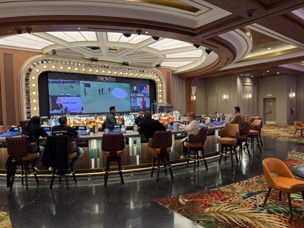 A half circle bar with large screens behind the wall playing sports. 