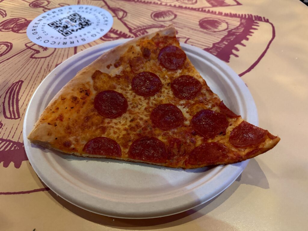A slice of pepperoni pizza on a paper plate. 