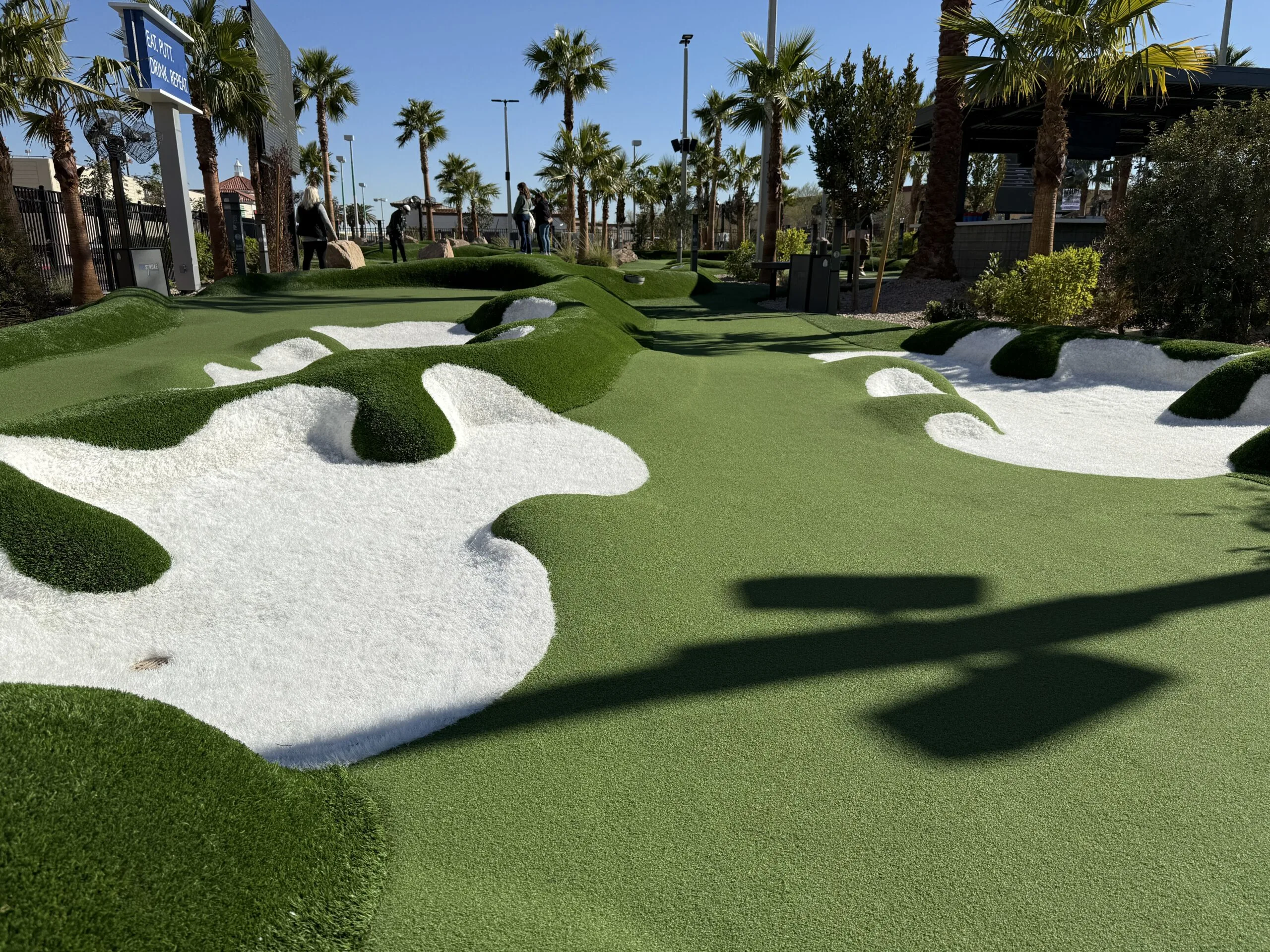 A golf hole at Popstroke, which has a fairway, and is surrounded by bunkers.