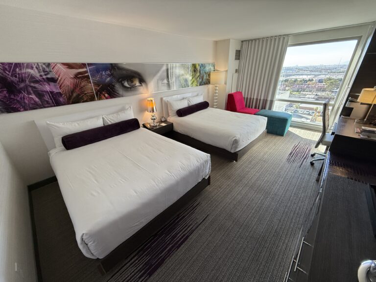 A wide angle photo of the room with 2 queen beds in the foreground.