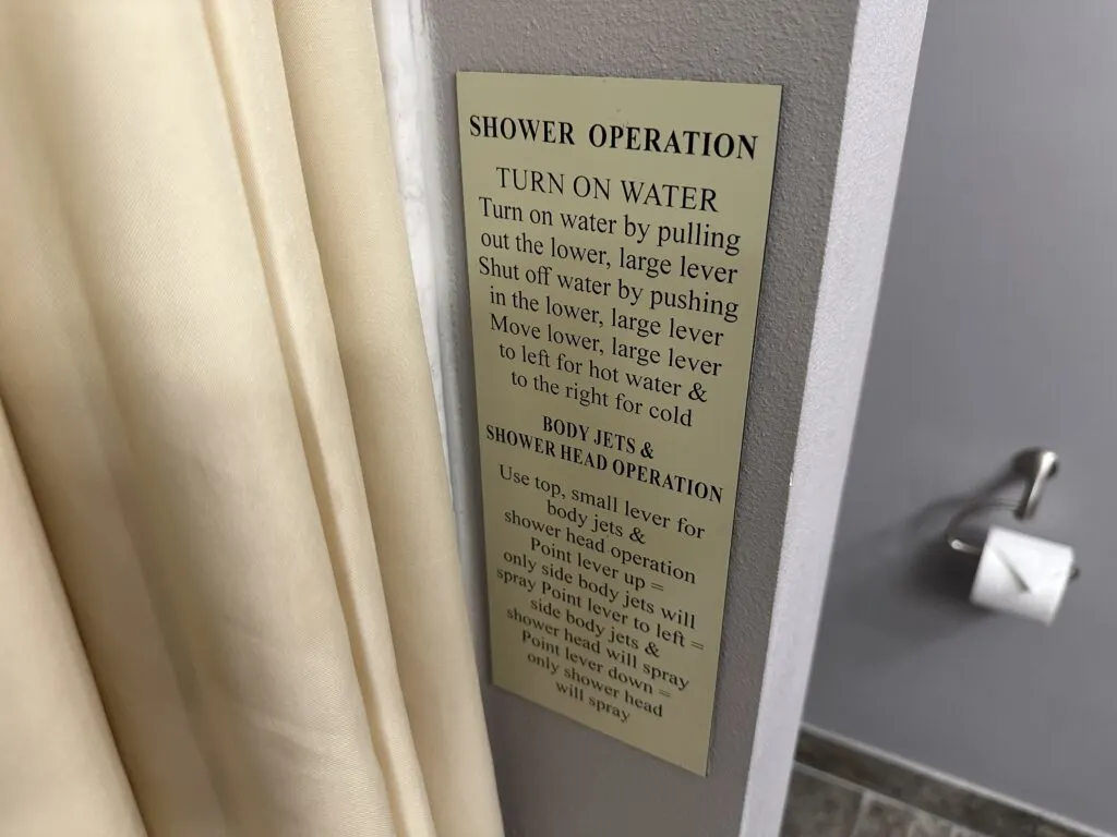 Lengthy written instructions on a plaque next to the shower.