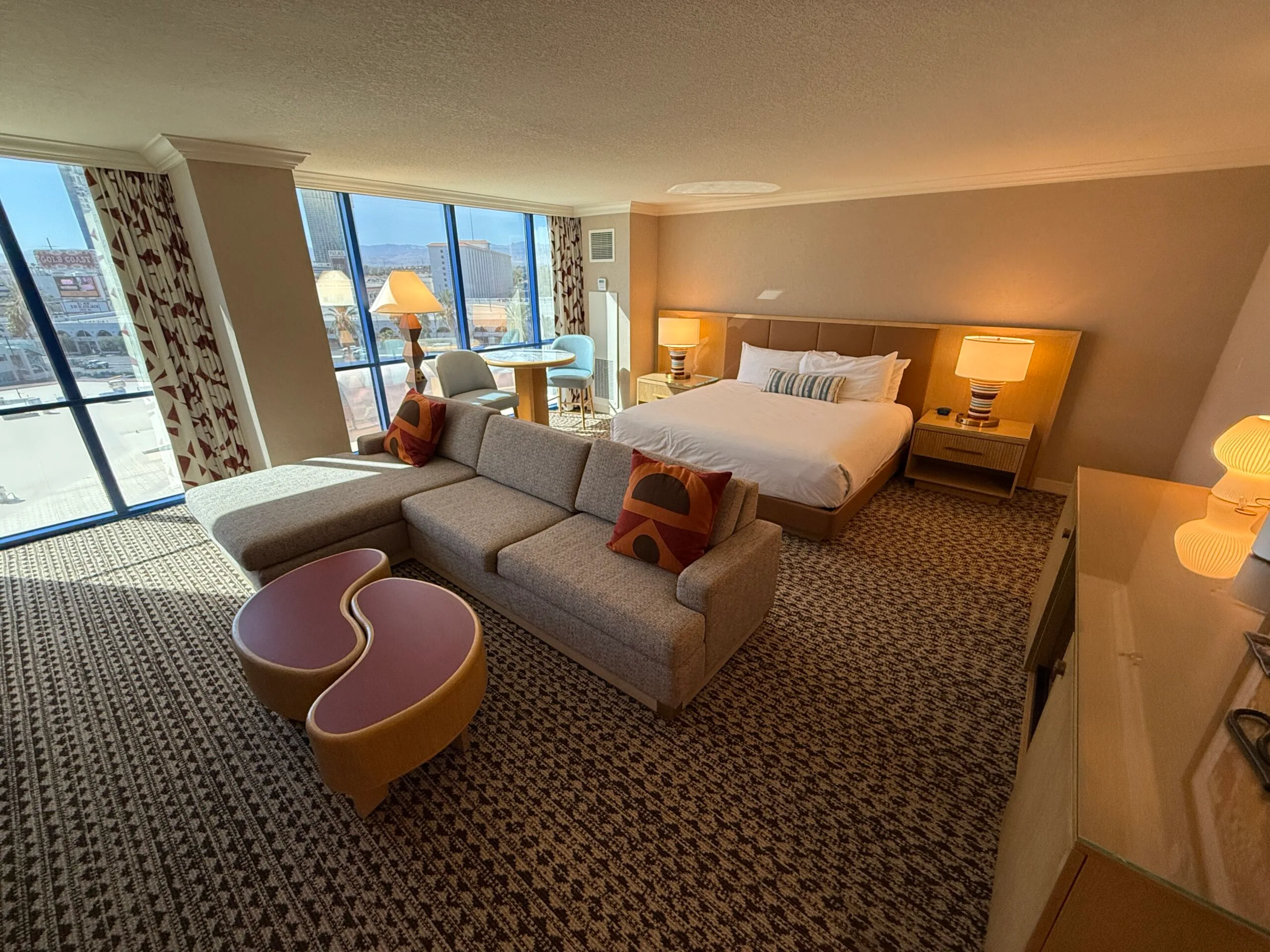Wide angle of the entire king suite with the living area in the foreground and bed in the background.