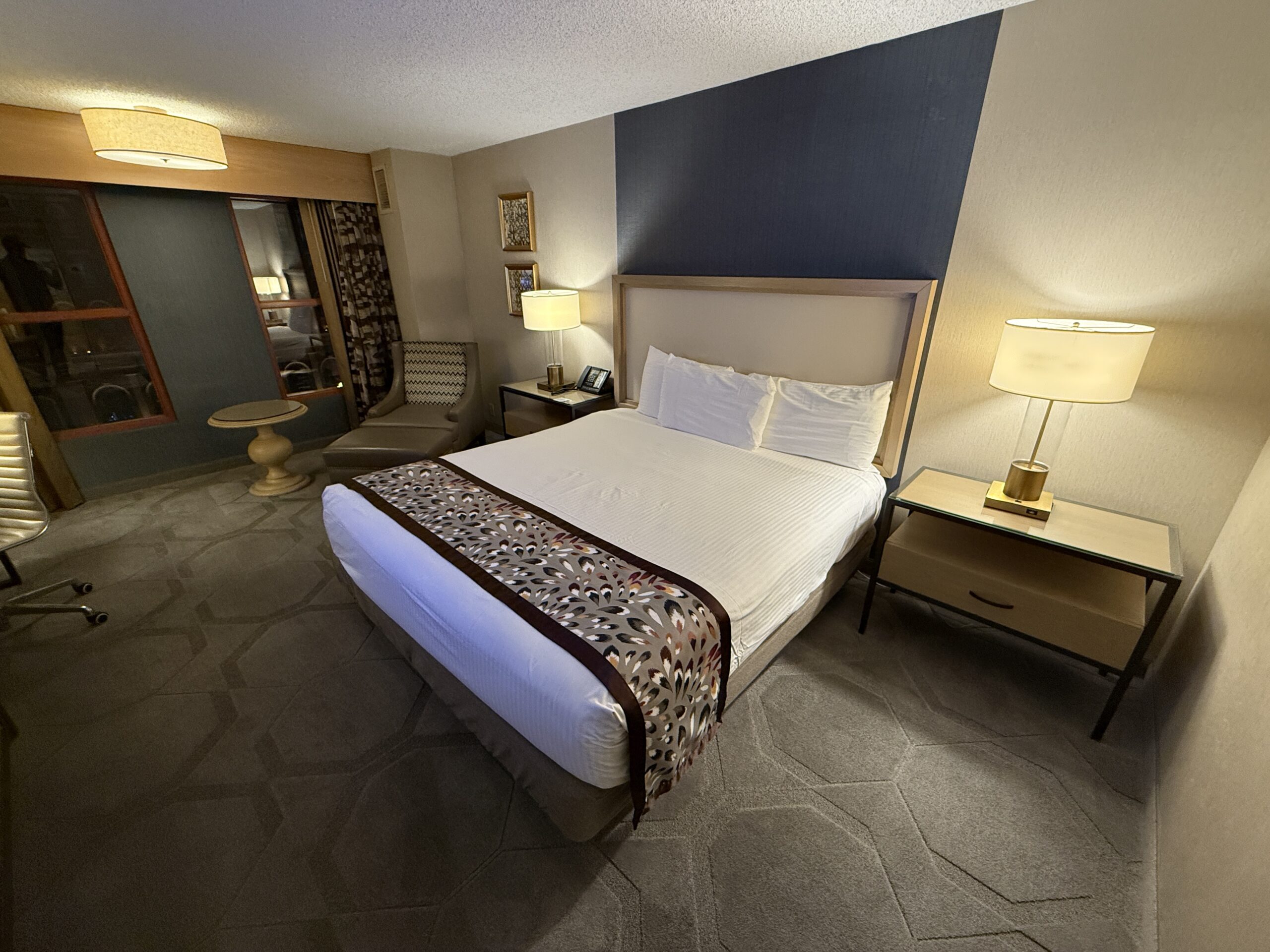 A wide angle shot of the room. The king bed prominently displayed.
