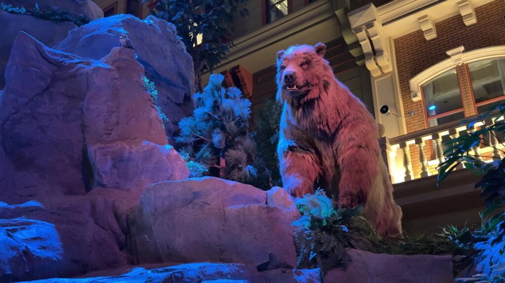 An animatronic bear up on a rocky hill. 