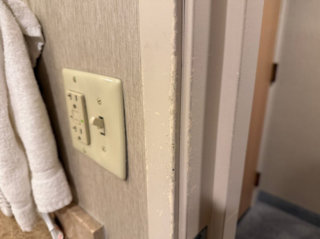 A doorframe with peeling and chipped paint. 