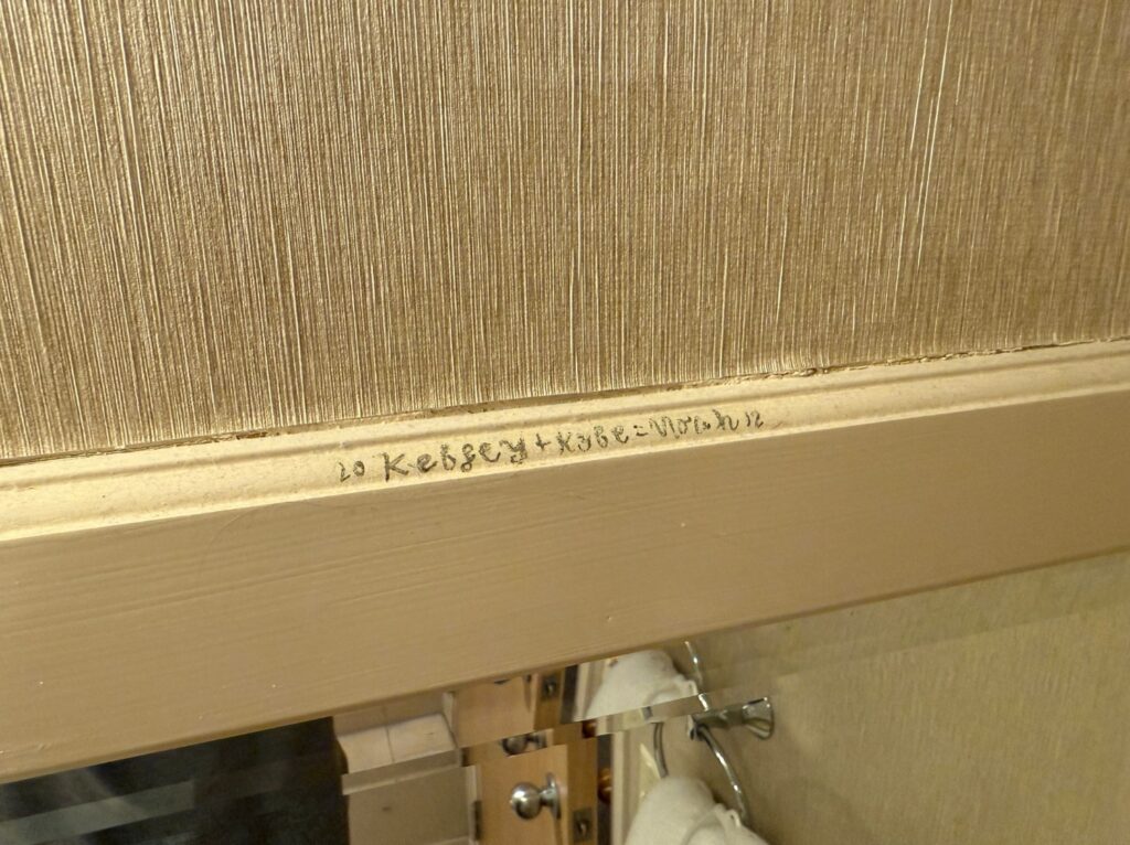 Unreadable writing on the mirror frame. 