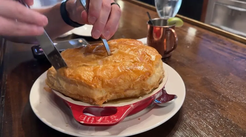 Ike cutting into the pot pie at Triple George.