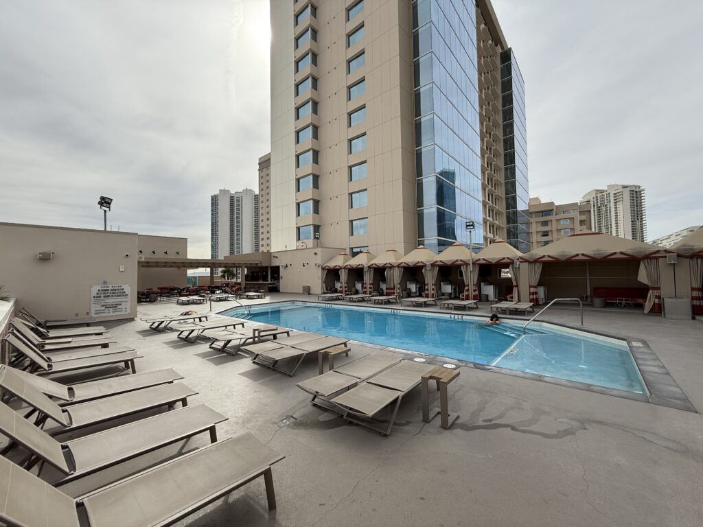 A small, quiet pool on the rooftop surrounded by loungers. 