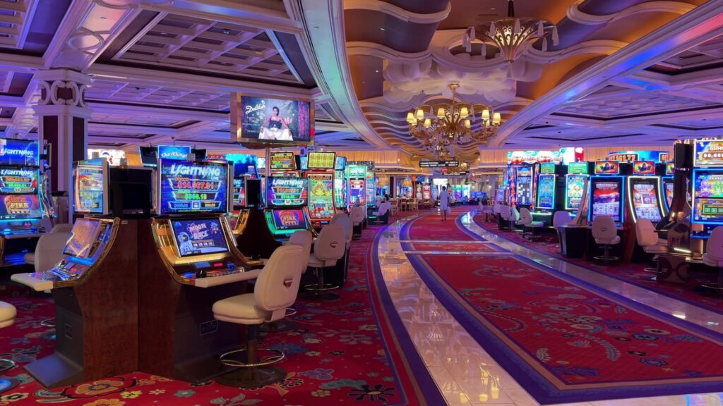 The casino floor at Wynn - A pathway is lined with slot machines. 