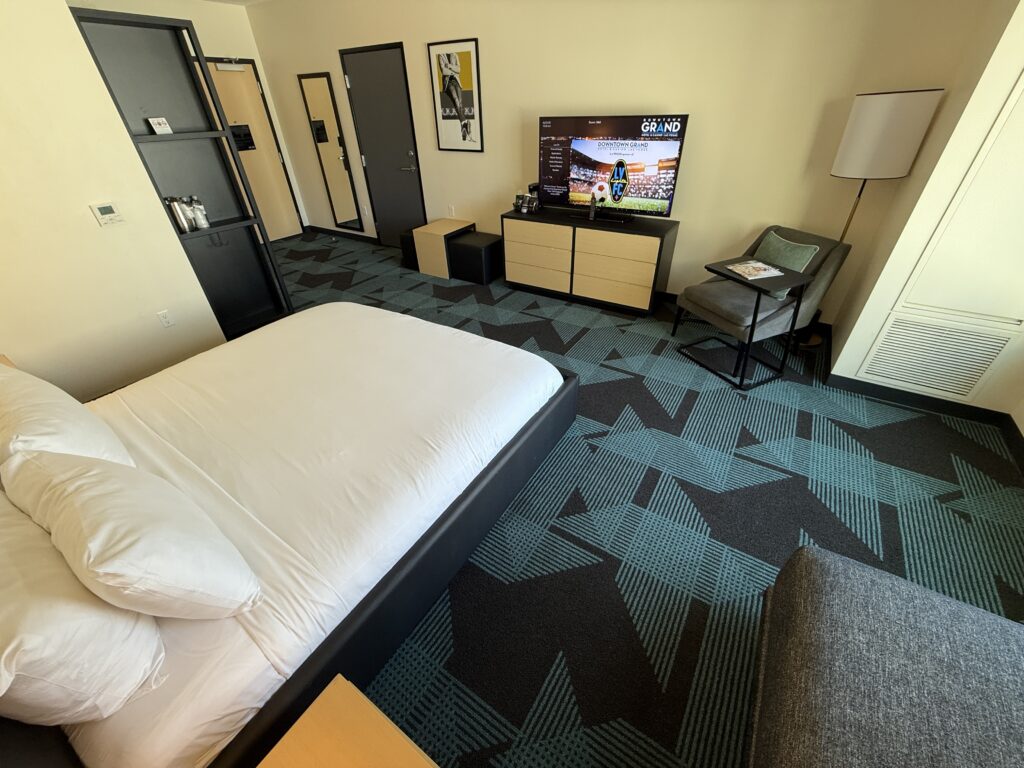 Wide angle of a Gallery Tower room with the bed in the foreground, facing the TV. 