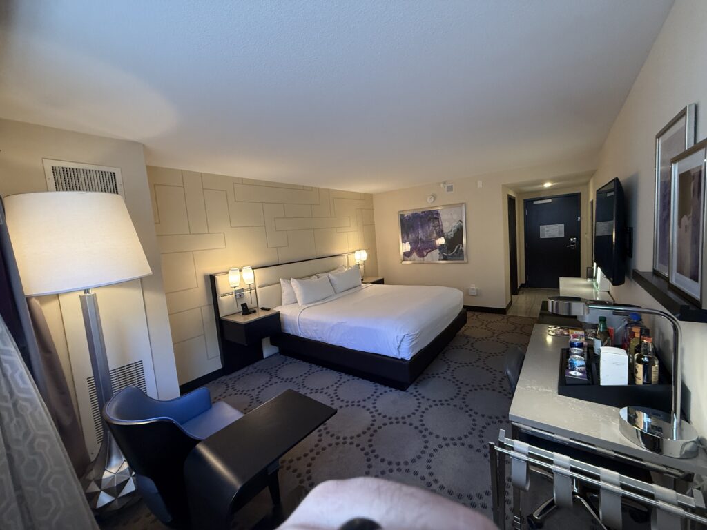 A wide angle shot of a king bed hotel room at Harrah's. 