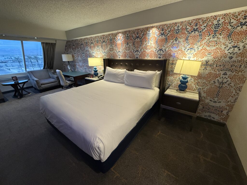 Luxor's Pyramid Premier room, with a king bed in front of a colorful accent wall. 