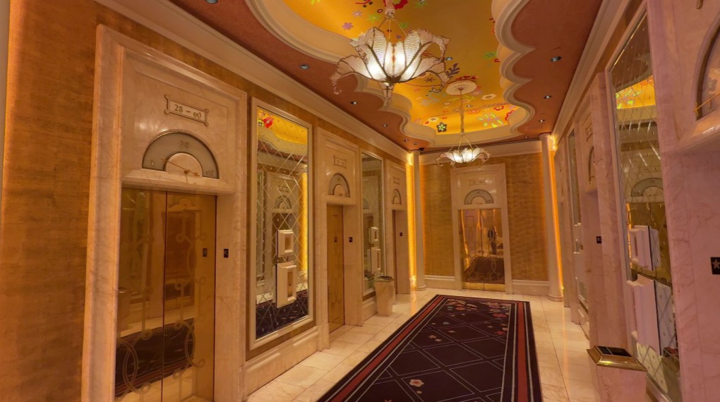Hotel elevator lobby, with decorative, flower chandeliers above. 