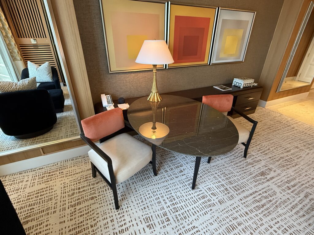 An oval shaped table with 2 chairs jutting out from the wall. 