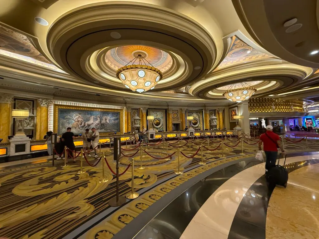 The hotel front desk, which has a Roman tile mosaic on the wall behind it.