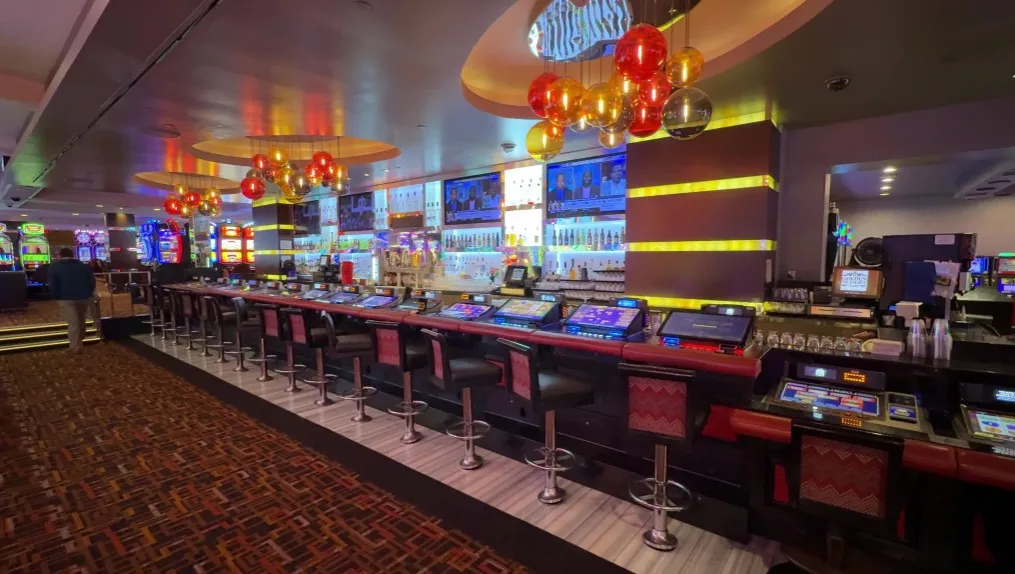A casino bar with bartop VP and illuminated orbs of glass hanging from the ceiling. 