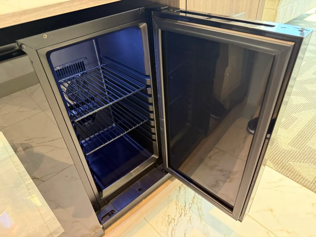 An empty mini fridge, opened. 