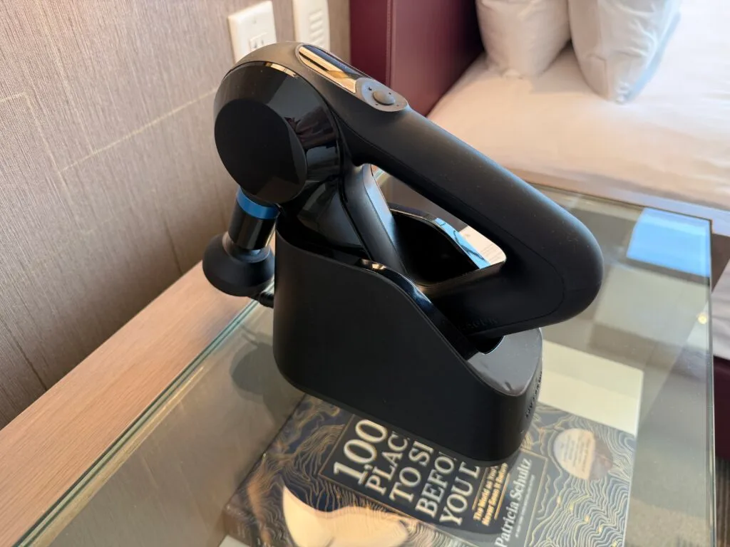 A message gun, charging bedside on an endtable. 