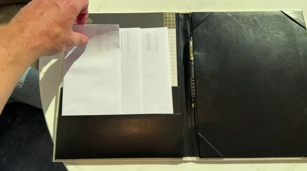 A black folio opened to show envelopes and stationary. 