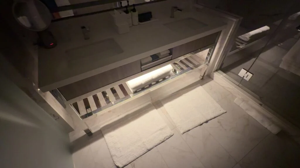 The bathroom vanity with the lights off, but nightlight illuminating the floor. 