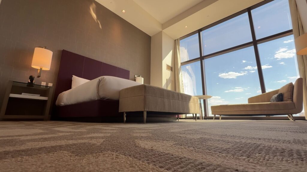 A shot of the room from the angle of the floor, looking up at the bed and windows.