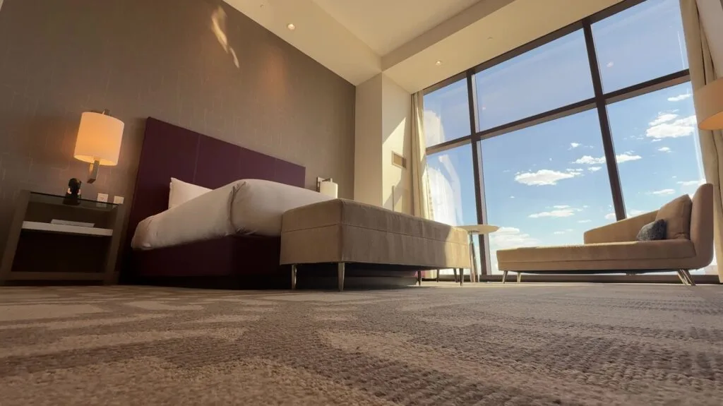 A shot of the room from the angle of the floor, looking up at the bed and windows. 