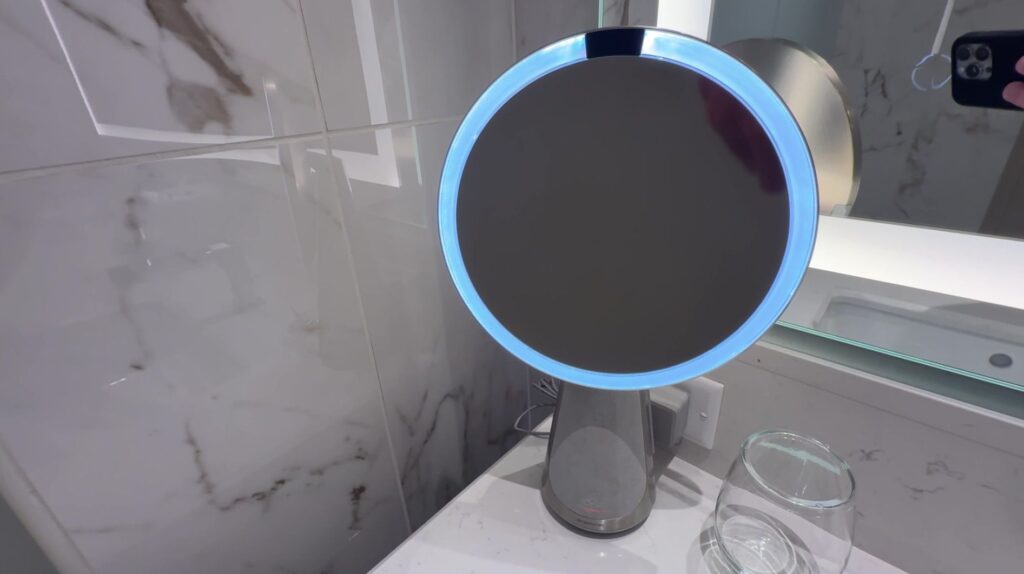A makeup mirror with a blue, motion activated light around the edge.