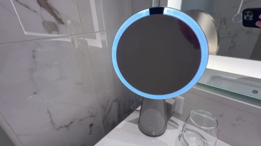 A makeup mirror with a blue, motion activated light around the edge. 