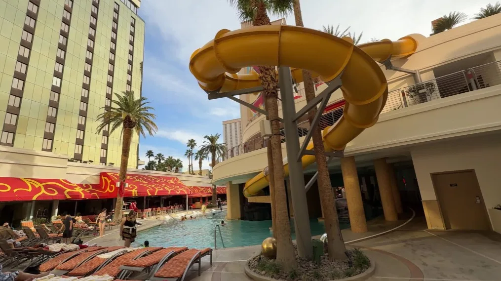 A yellow waterslide winds above the pool scene. 
