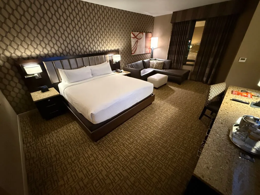 A king bed flanked by two illuminated lamps. 