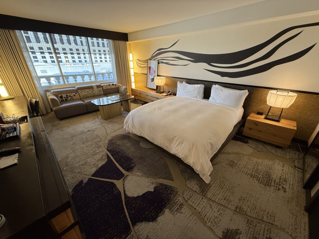 The king bed with a zebra striped accent wall above it.