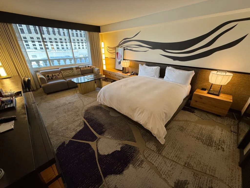 The king bed with a zebra striped accent wall above it.