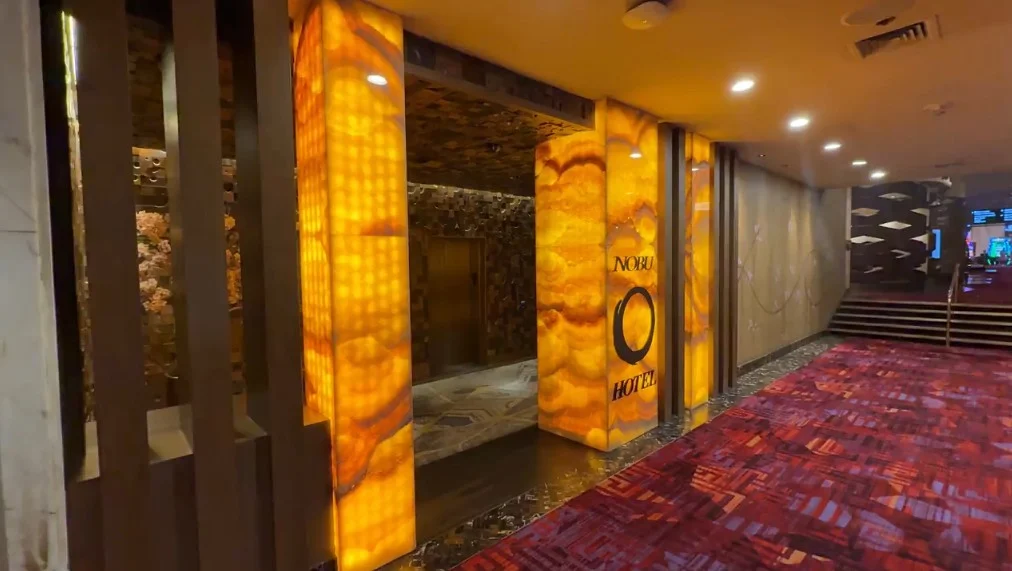Entrance to Nobu's Elevators, which has an amber colored illuminated sign.