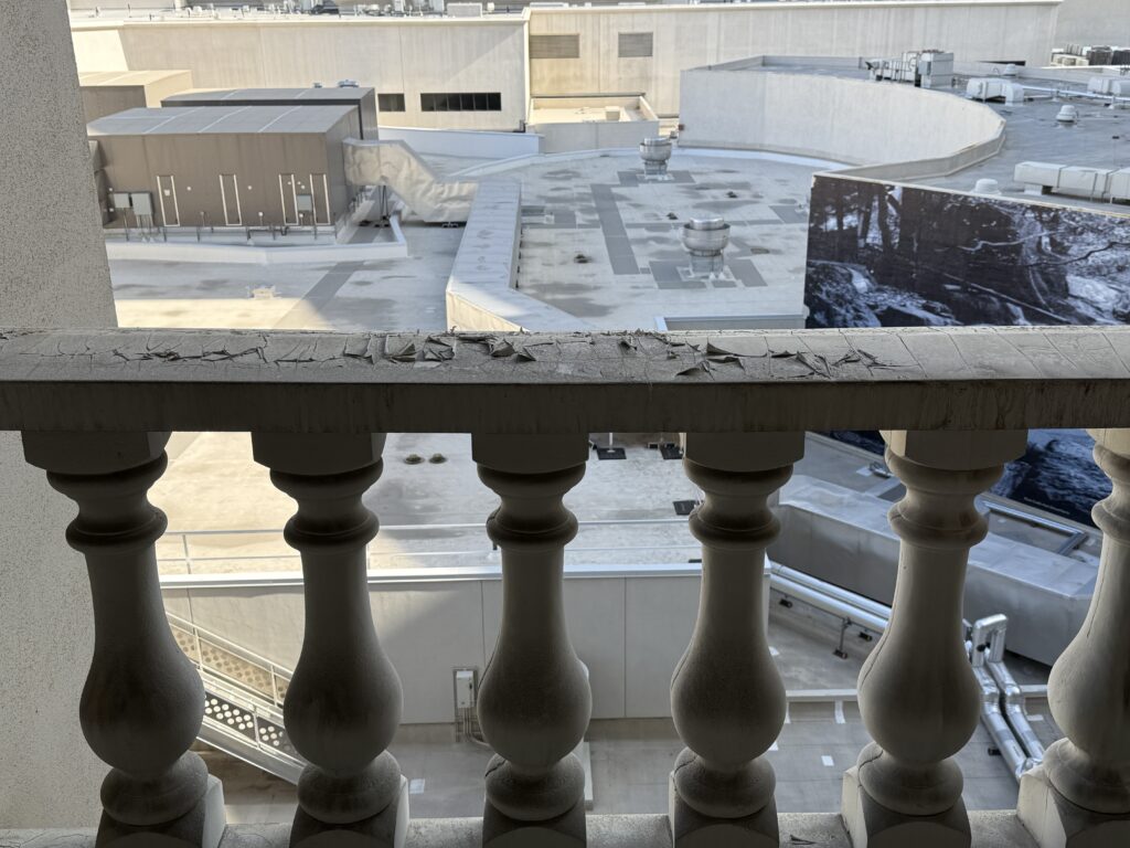 Peeling paint on the balcony railing outside my window.