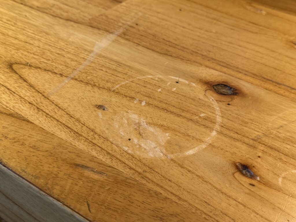 A circular ring of water damage on a wooden surface.