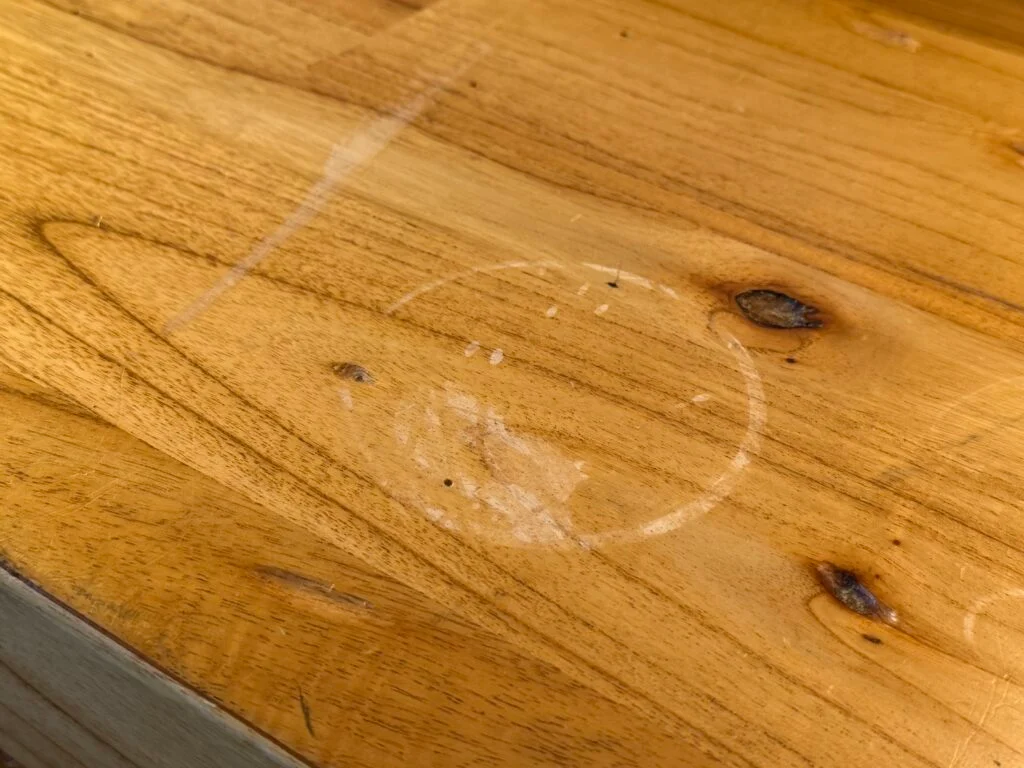 A circular ring of water damage on a wooden surface.