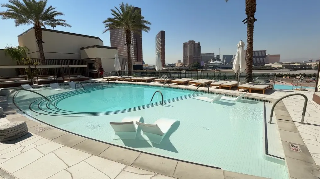 The upper level of the infinity pool, with chairs submerged in the water. 