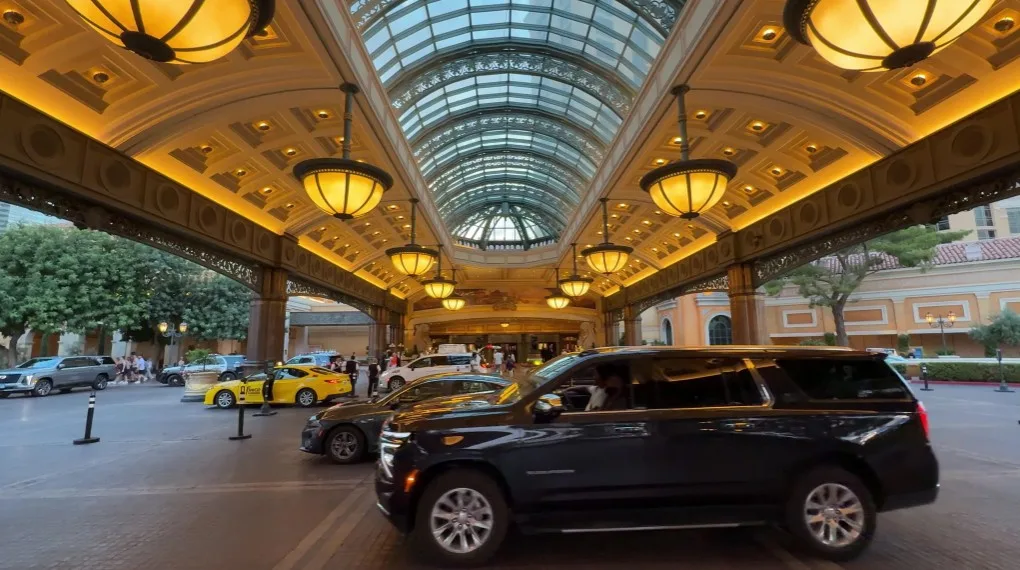 Bellagio's Porte Cochere at dusk, with the overhead, decorative lights illuminated. 