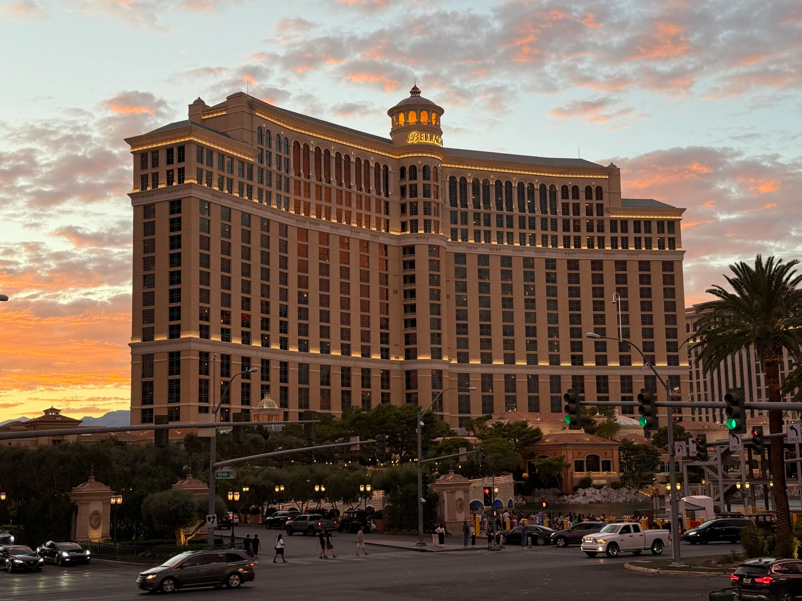 Bellagio's hotel tower at dusk, the sky behind it aglow in pinks at sunset.
