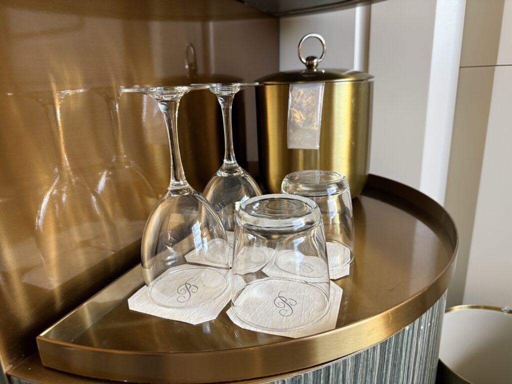 4 glasses upside down in front of a metal ice bucket.