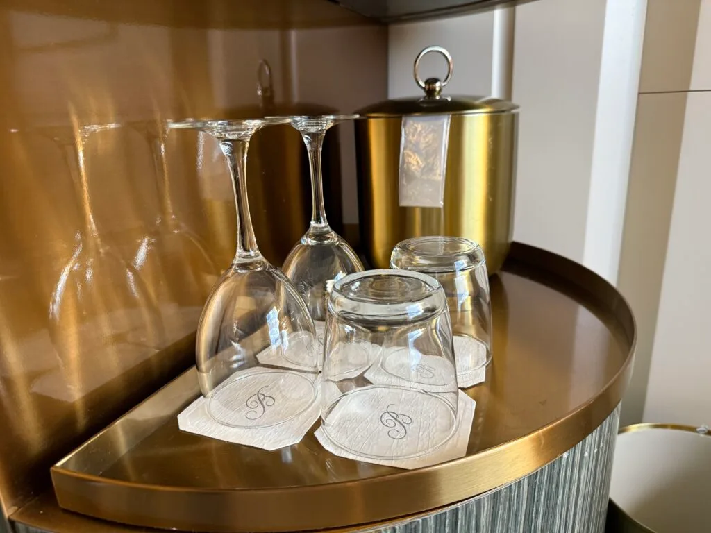 4 glasses upside down in front of a metal ice bucket. 