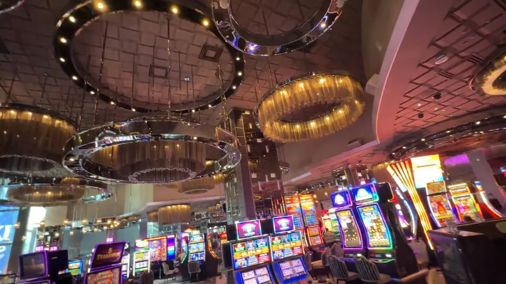 Casino floor at The Cosmopolitan, with decorative light fixtures overhead. 