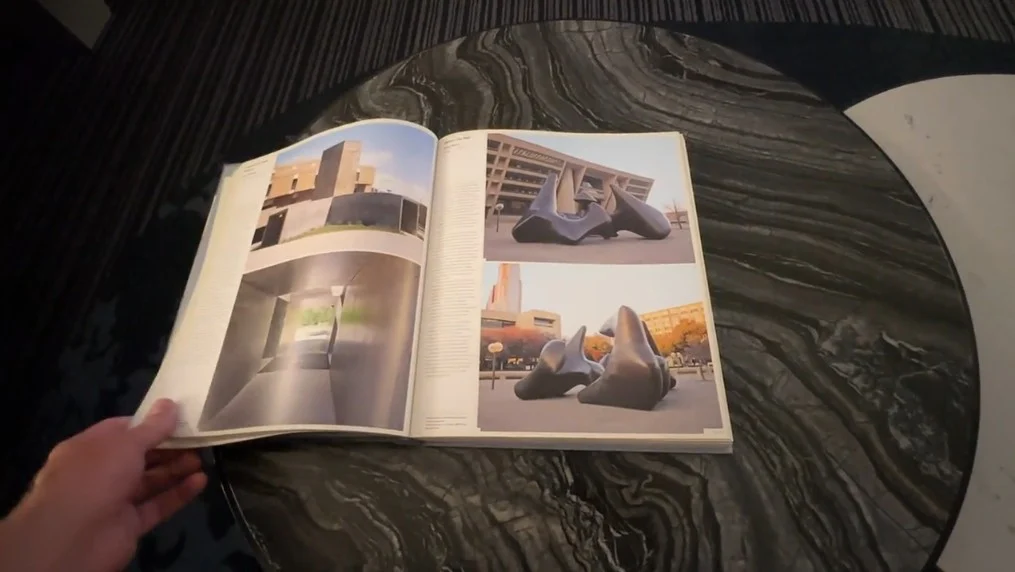 A book, open to a page showing sculptures. 