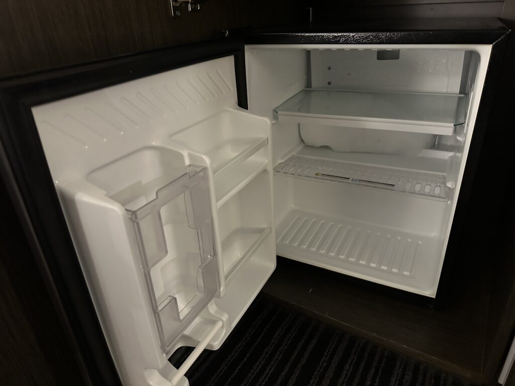 An empty mini-fridge, open.